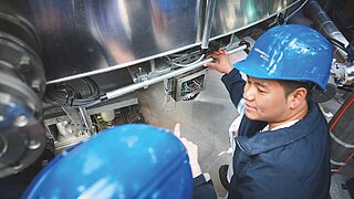 Two technicians investigating a machine