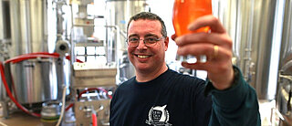 Picture showing a man holding a beer