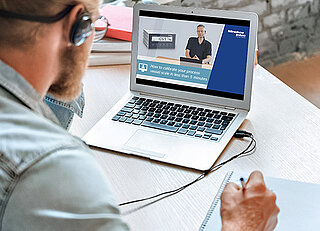 A Person watching a webinar on his Laptop