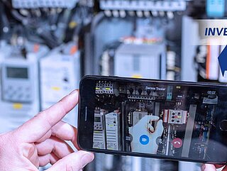 Eine Person benutzt miRemote auf einem Smartphone vor einer Maschine
