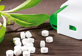 White pressed mint tablets with container and ment leaf