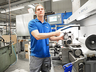 Das Bild zeigt einen Auszubildenden von Minebea Intec bei der Arbeit in der Produktionsstätte in Hamburg