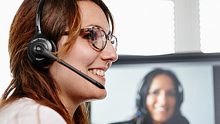 Woman with a headset attending an online seminar