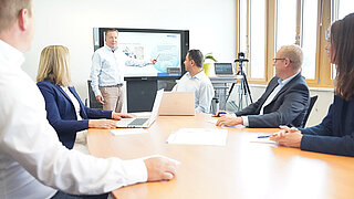 A group of minebea intec employees in a meeting