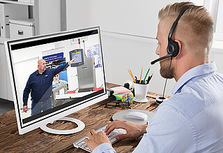 Hombre con auriculares observando a alguien que maneja una máquina