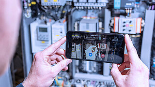 Someone is holding a smartphone to operate the service app miRemote