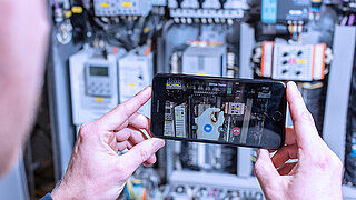 Someone is holding a smartphone to operate the service app miRemote