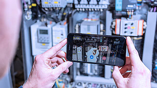Someone is holding a smartphone to operate the service app miRemote