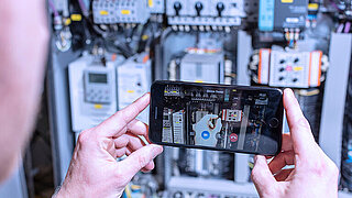 Someone is holding a smartphone to operate the service app miRemote